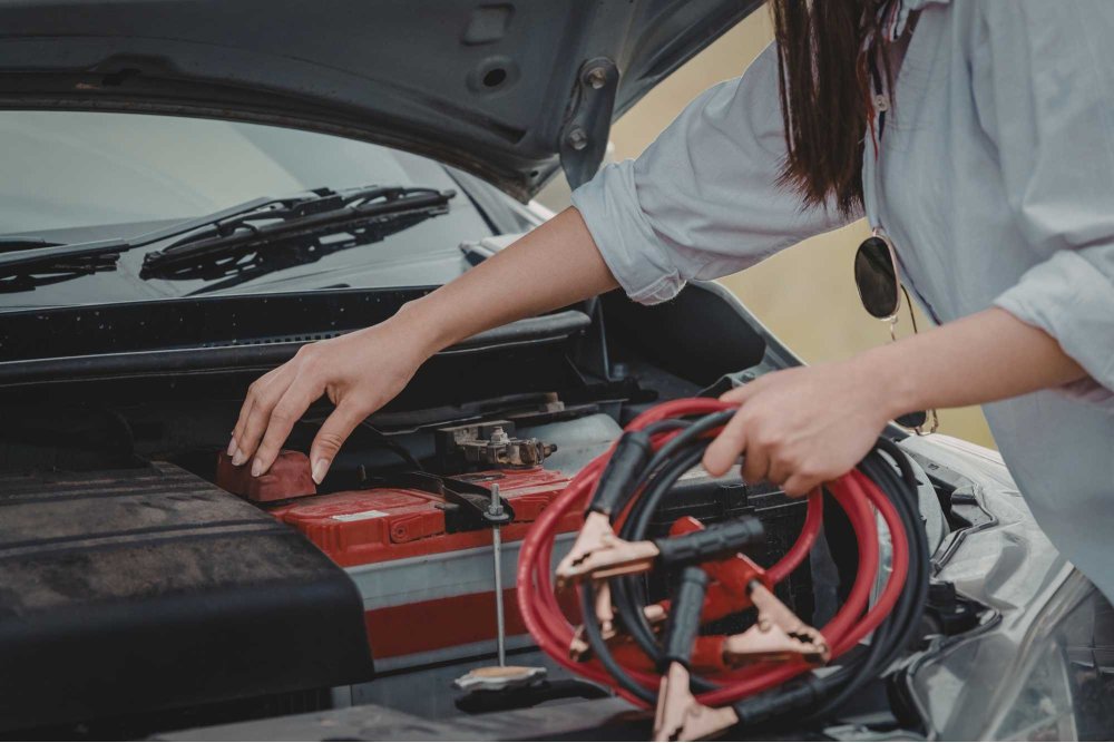 Žena pripája štartovacie káble na autobatériu